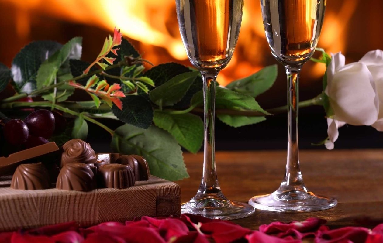 Chocolates, Champagne and roses in front of a fireplace