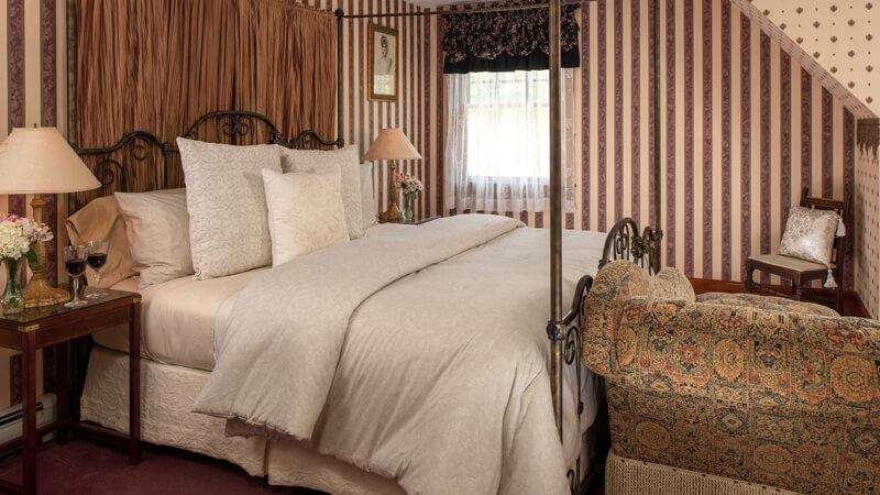 Romantic Bedroom at Palmer House Inn with brass poster bed and striped walls