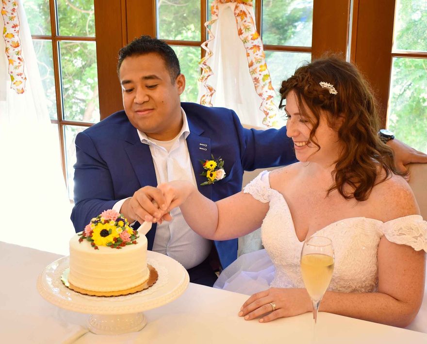 Bride and groom cutting wedding cake at their reception at the Palmer House Inn