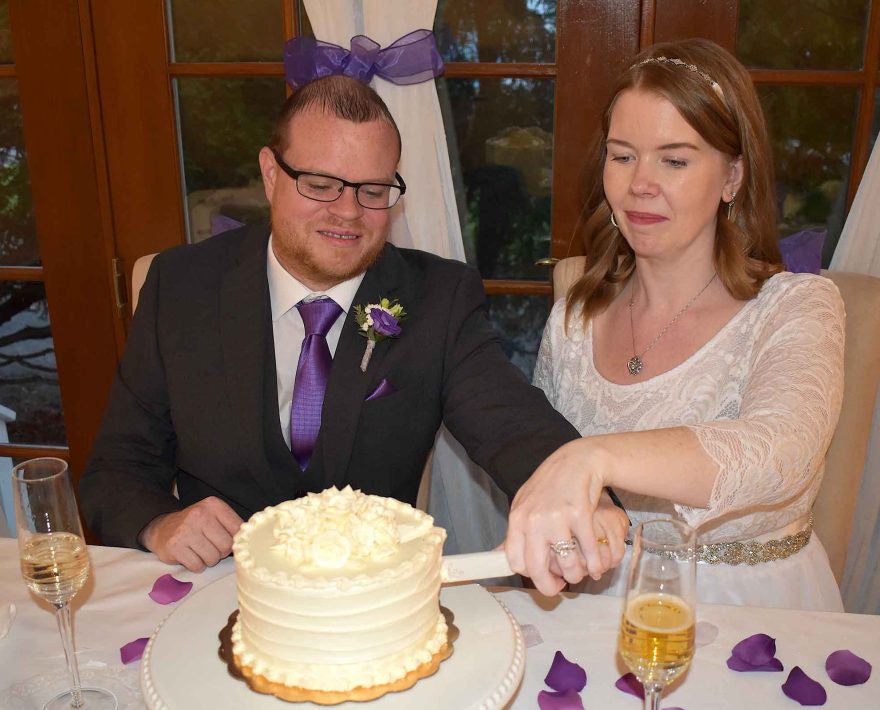 Bride and groom cutting wedding cake