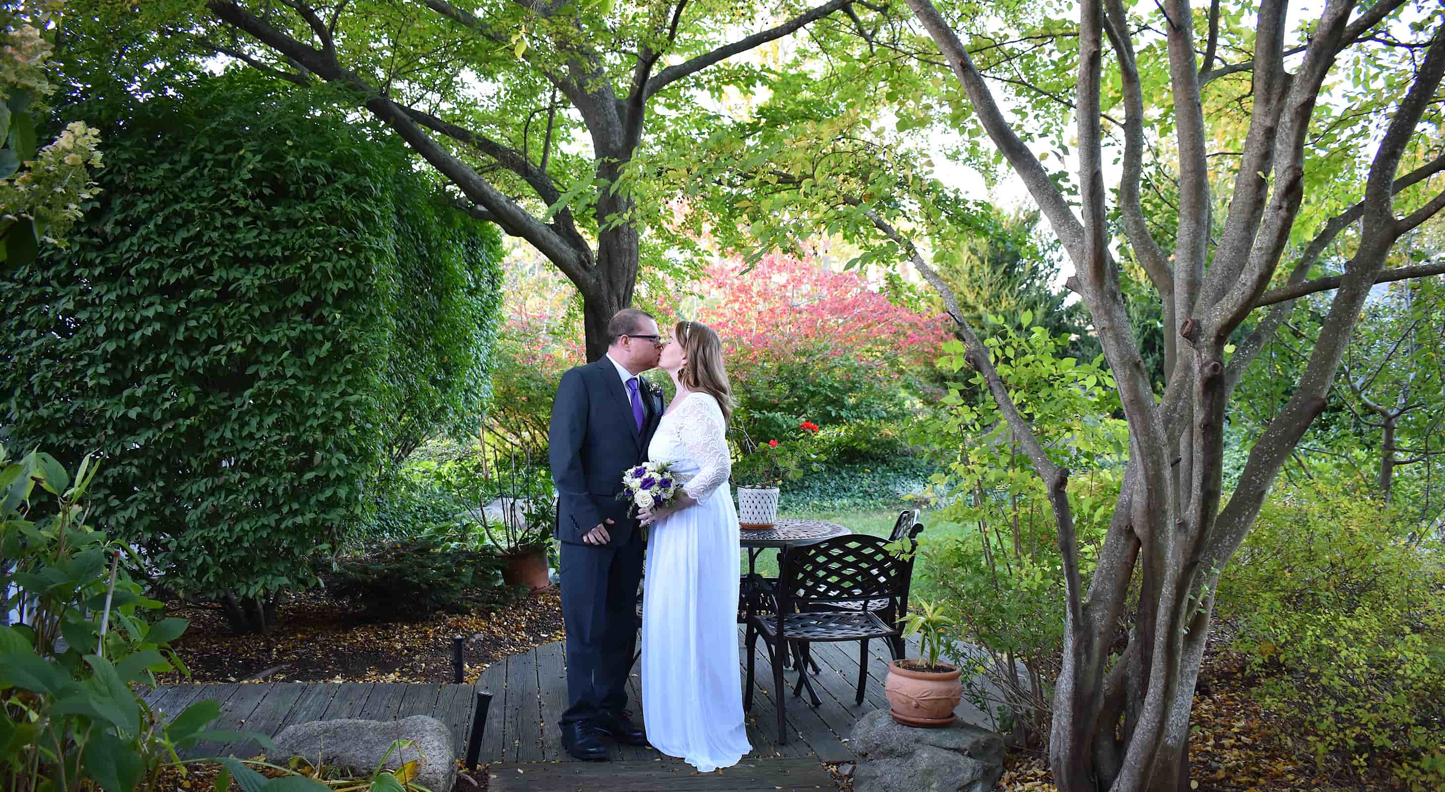 Bride and groom kissing in the round garden while eloping in MA