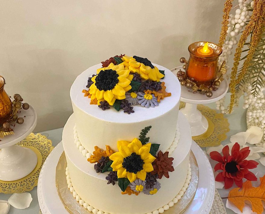 Wedding cake decorated with fall flowers and leaves