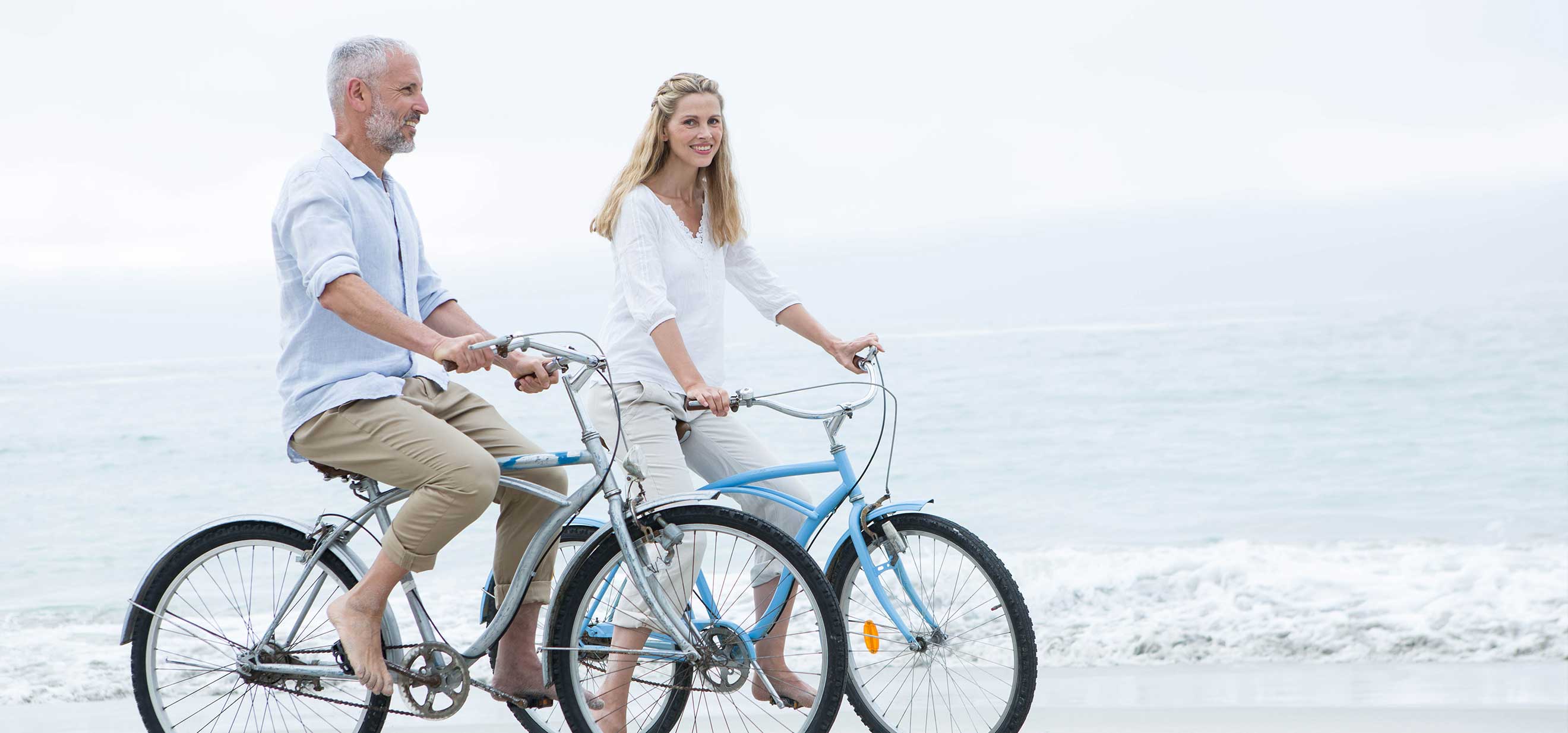 Couple riding bikes on beach