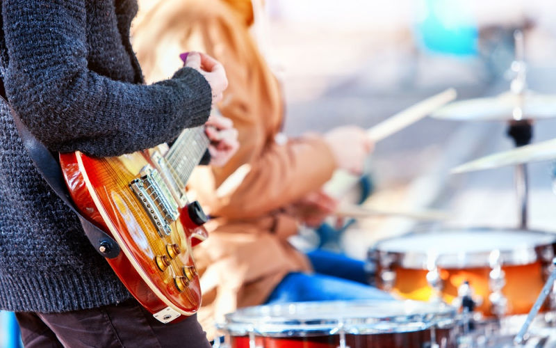 a man playing a guitar at an outdoor concert