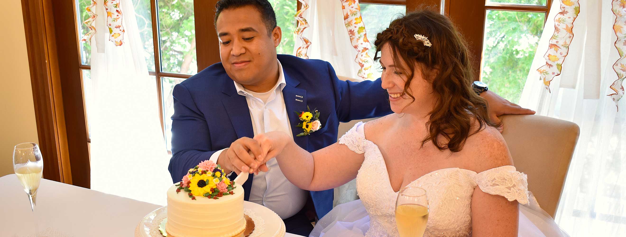 Bride and groom cutting wedding cake at their reception at the Palmer House Inn