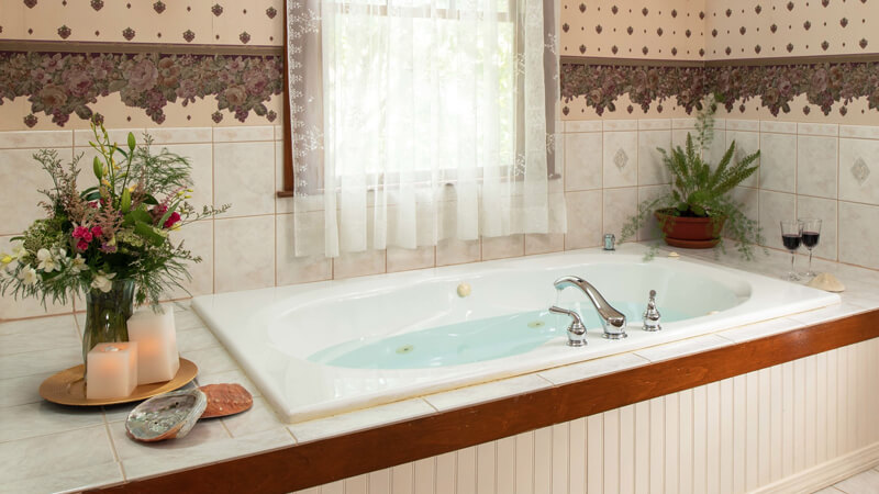 Romantic jetted tub with candles, flowers and wine
