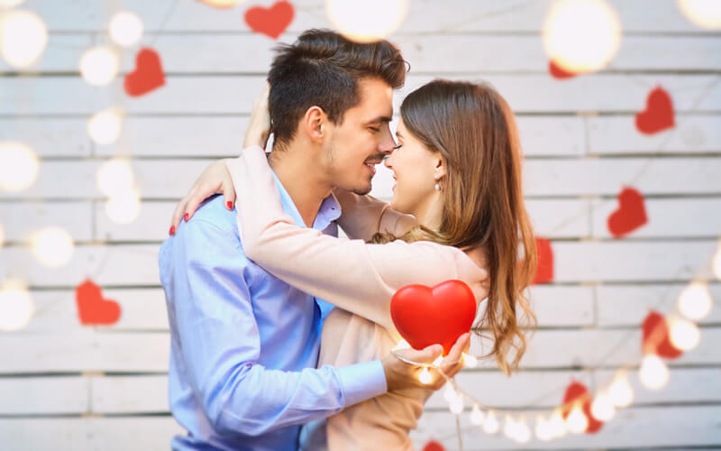 couple embracing with light and hears surrounding them