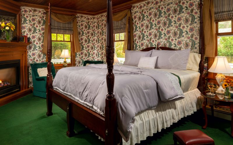 Victorian inn room with canopy bed and fireplace