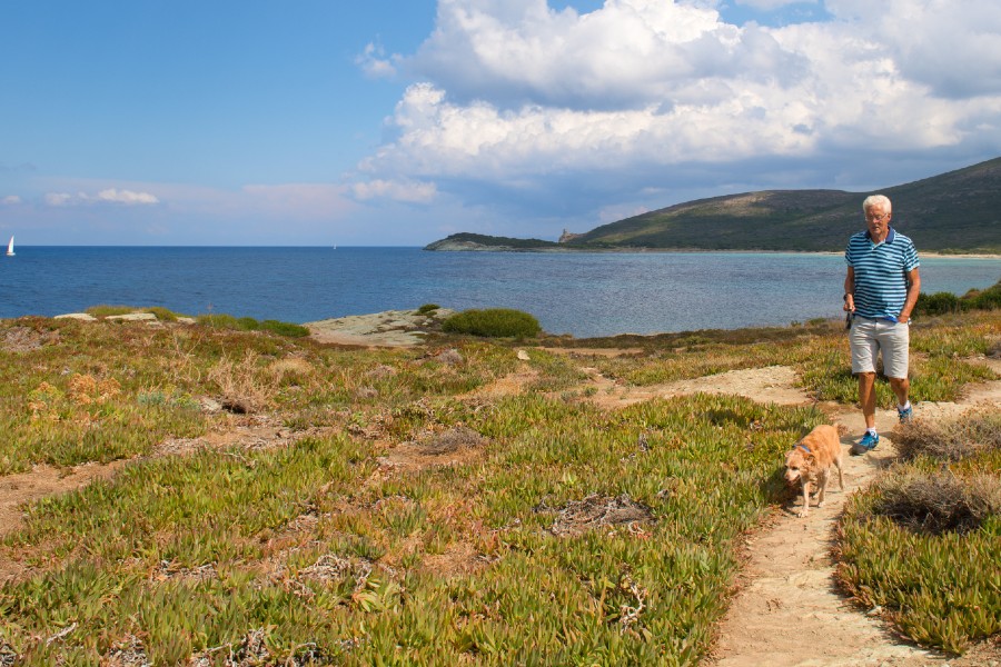 a man walking a dog near the ocean