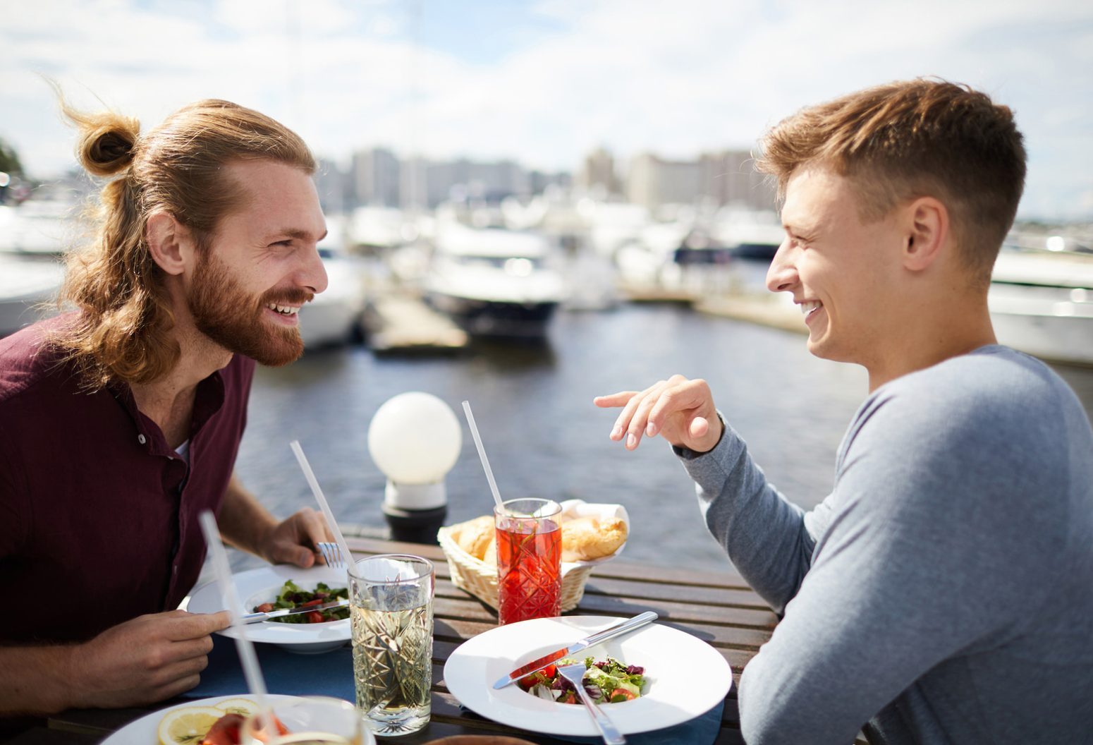 Two men dining on the harbor at a restaurant in Falmouth, MA