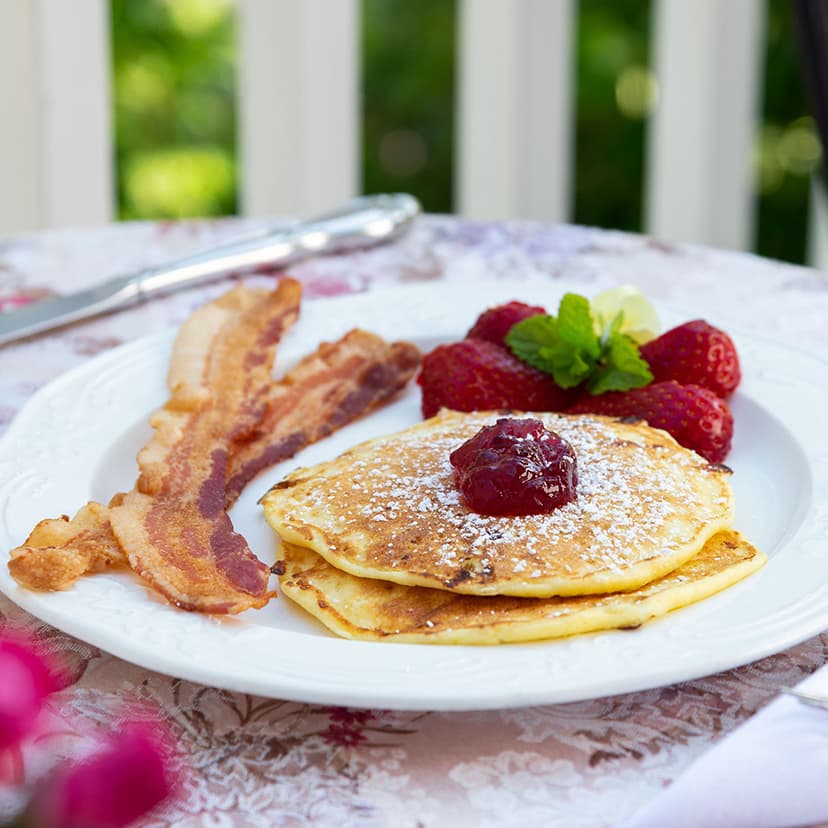 Pancakes and bacon on outdoor dining table at B&B in Falmouth, MA