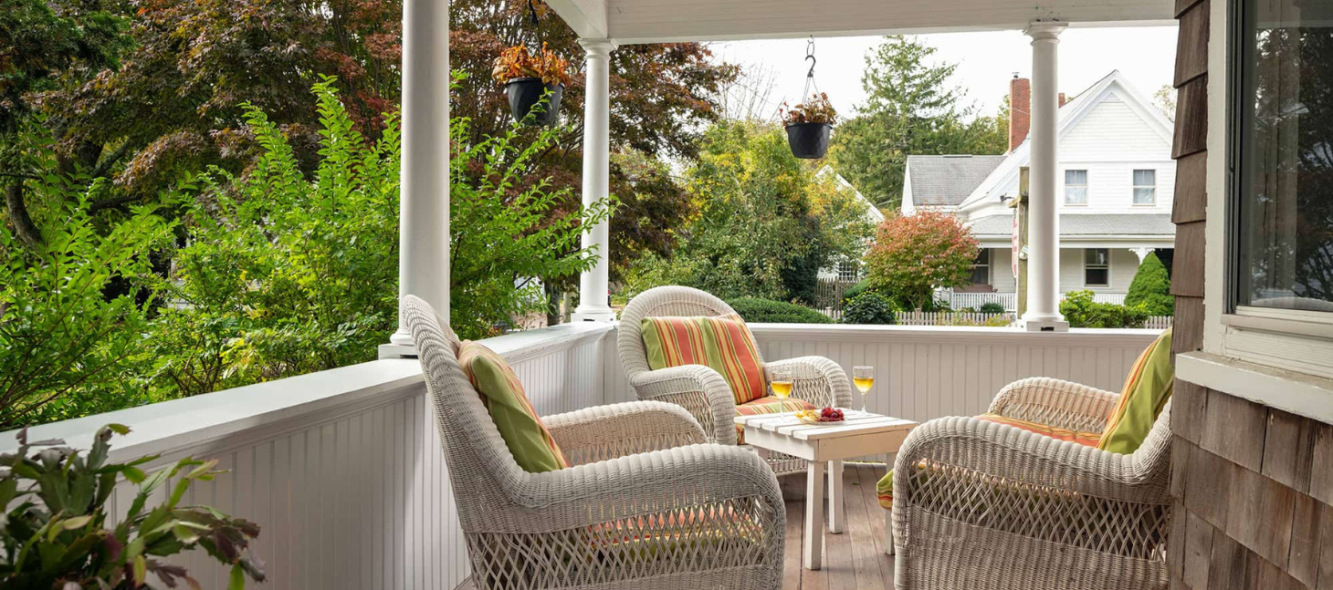 cozy porch at the palmer house inn with wicker chairs and colorful cushions