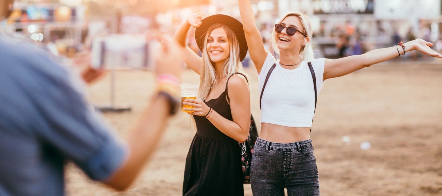 Friends smiling and posing for a photo at an outdoor festival